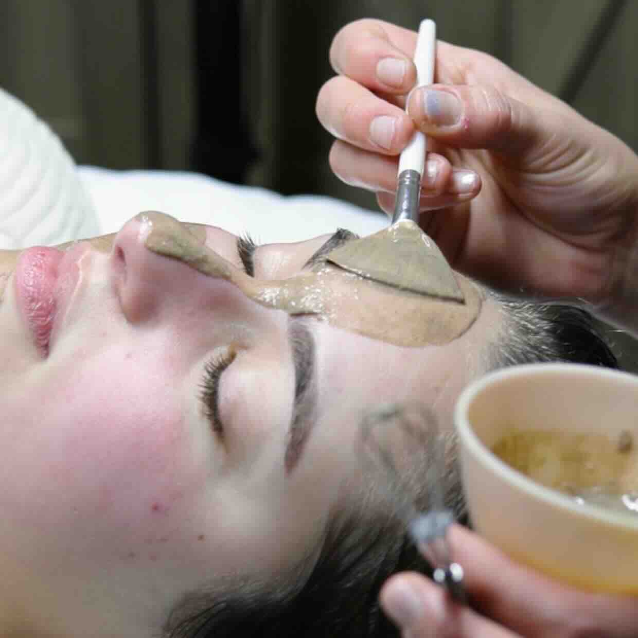Close-up of a woman's face receiving a facial treatment in a salon