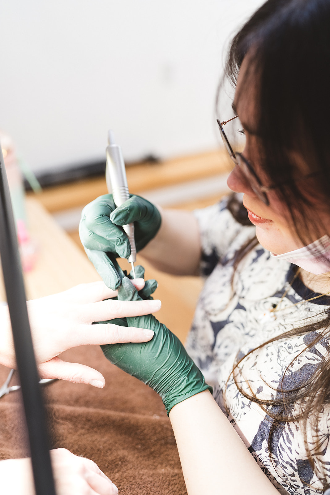 Nail technician applying manicure treatment