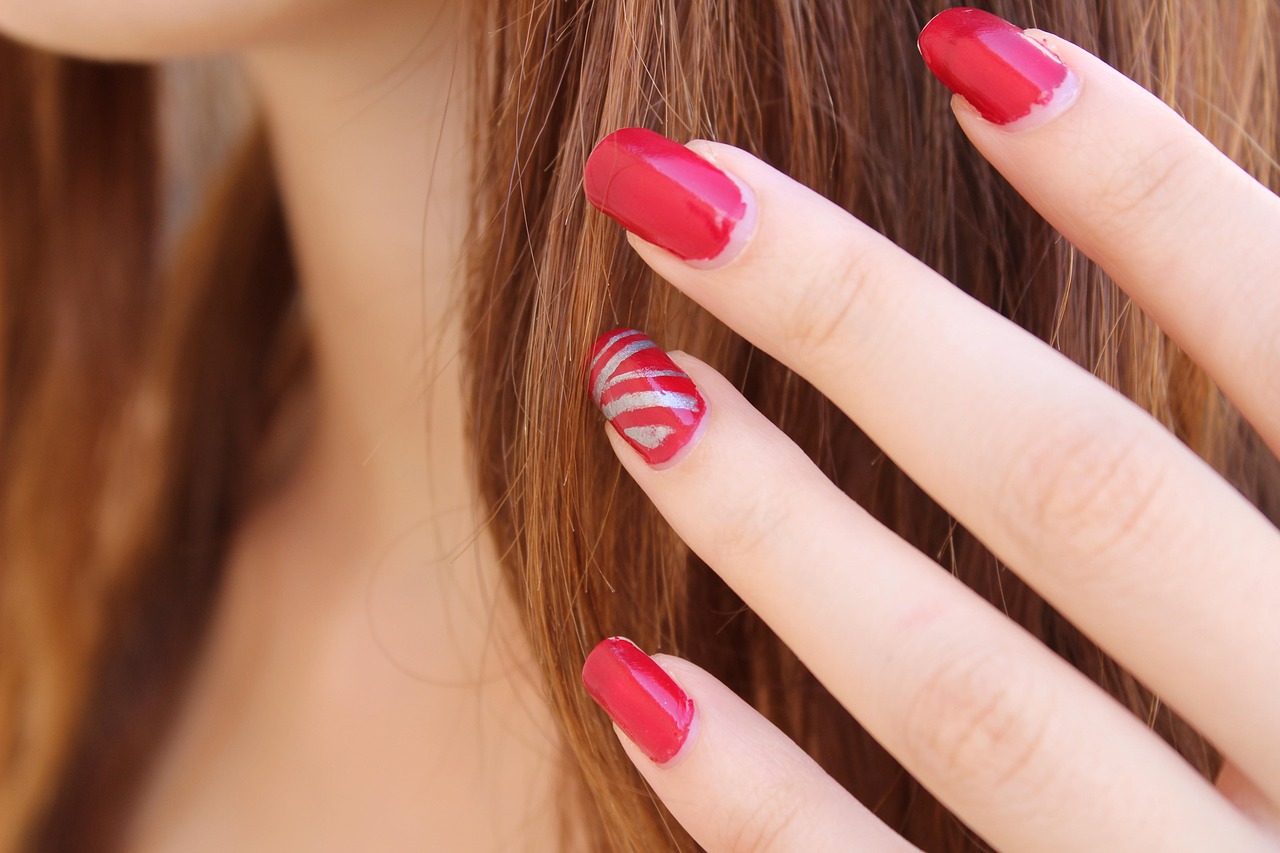 Close-up of red nail polish application