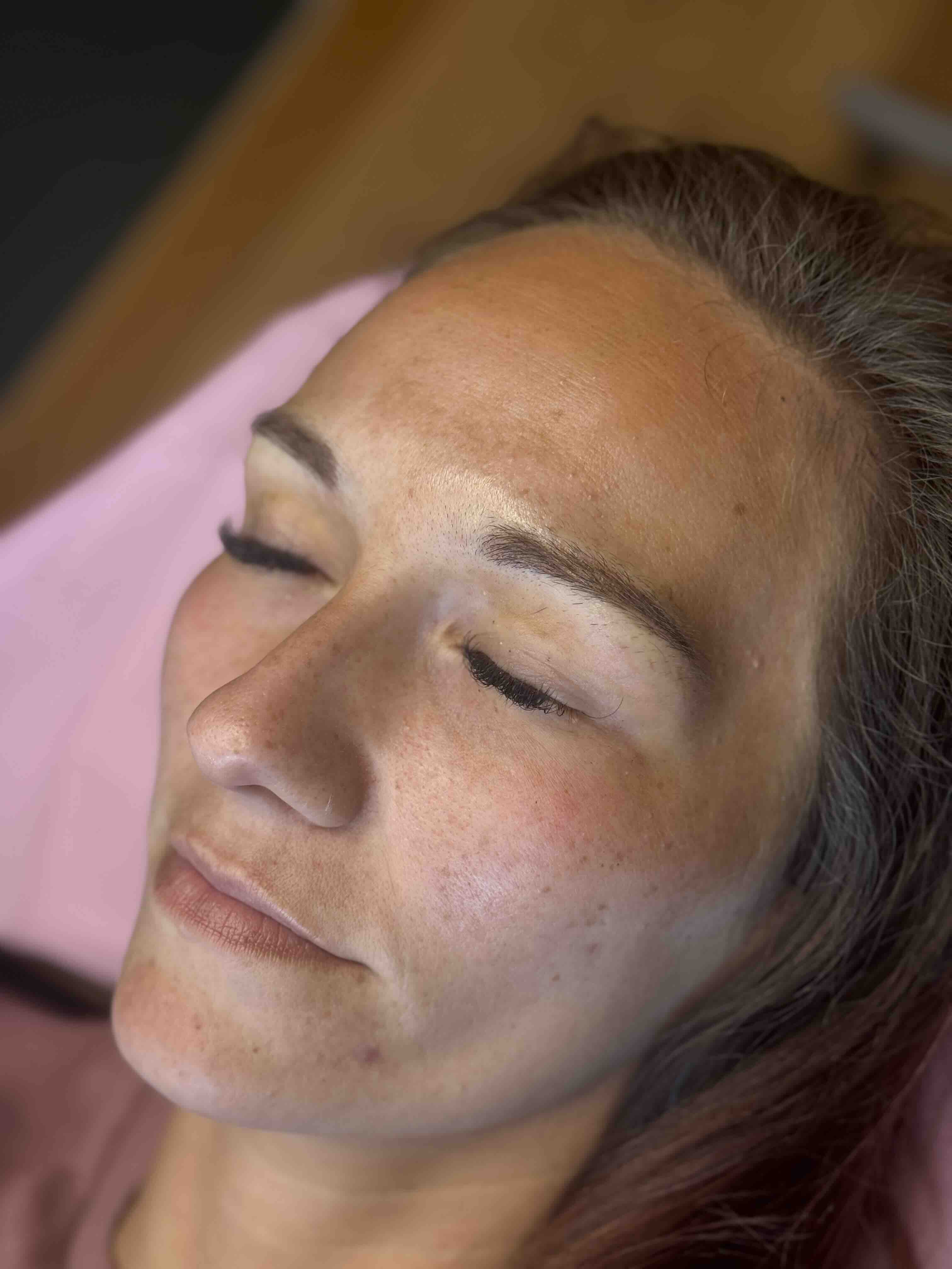 Close-up portrait showcasing permanent makeup — defined brows and polished look