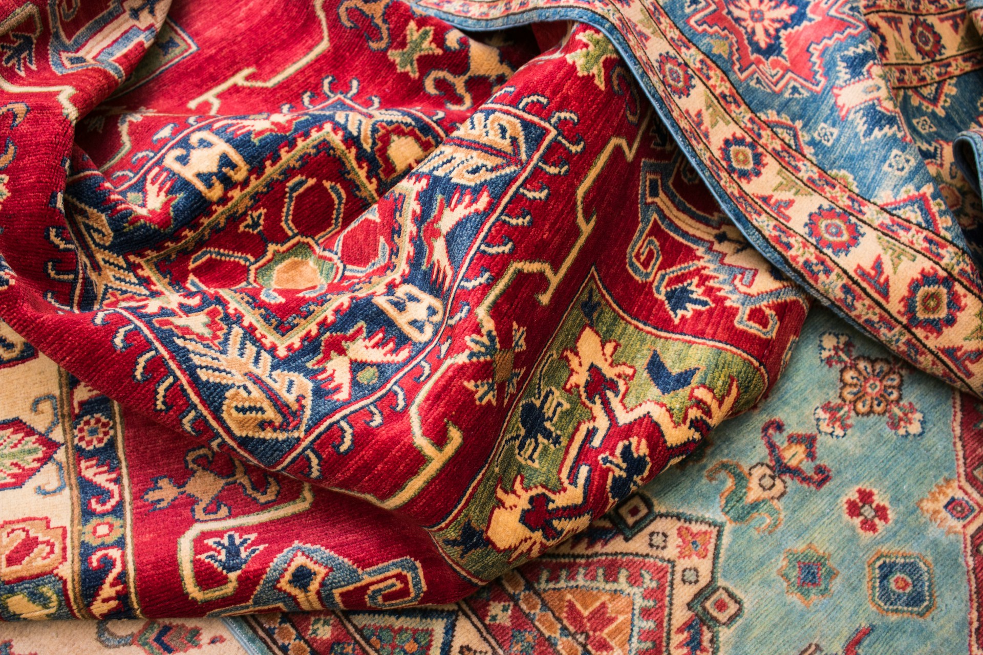 Richly-patterned Persian rugs displayed in warm light