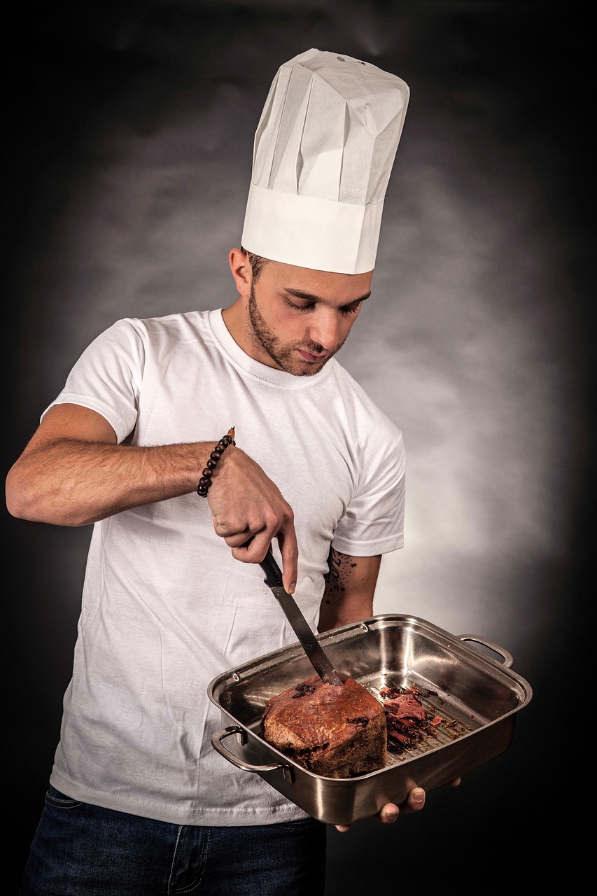 Skilled chef in whites focused on carefully preparing a gourmet meal