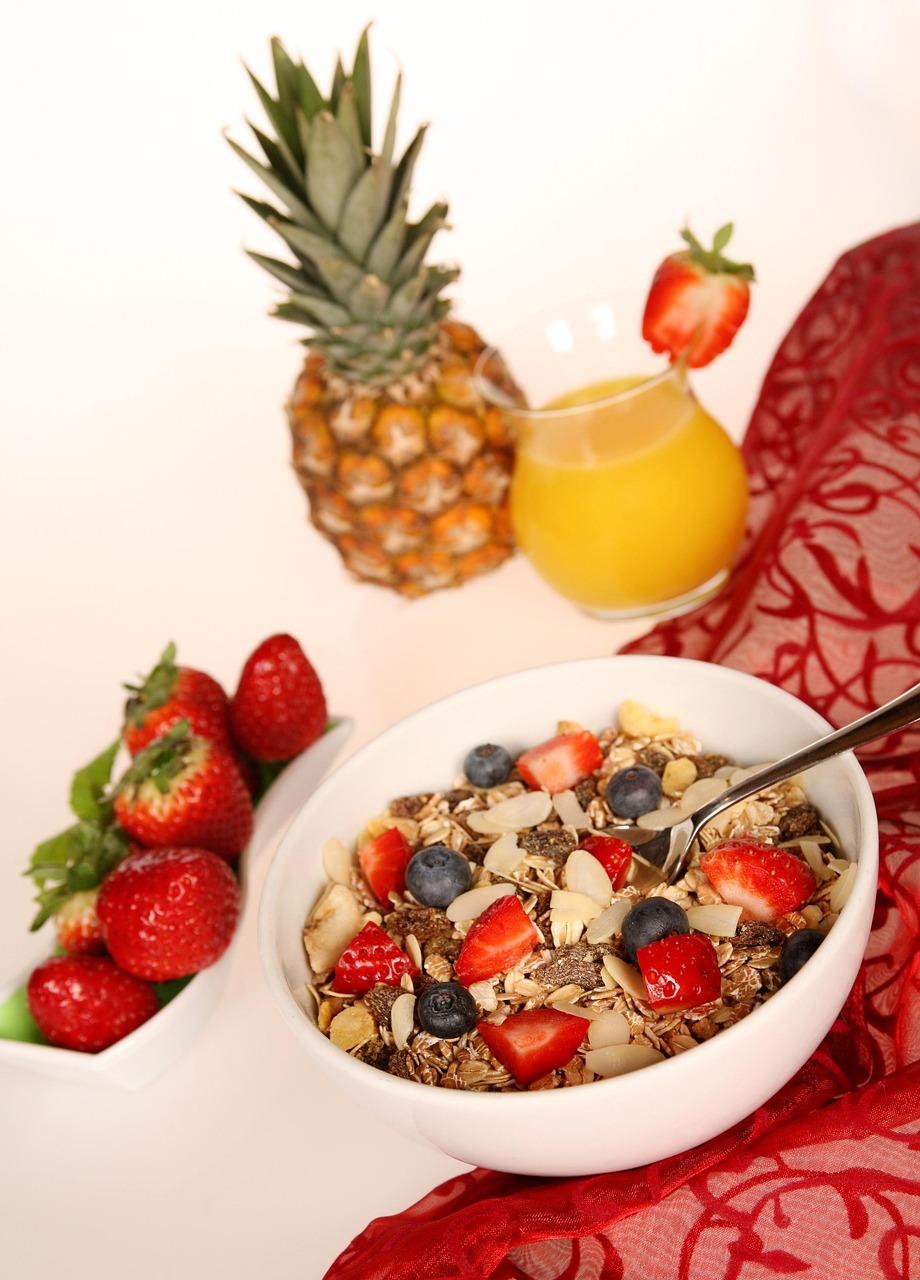 Colorful breakfast bowl with fresh fruit, granola and orange juice